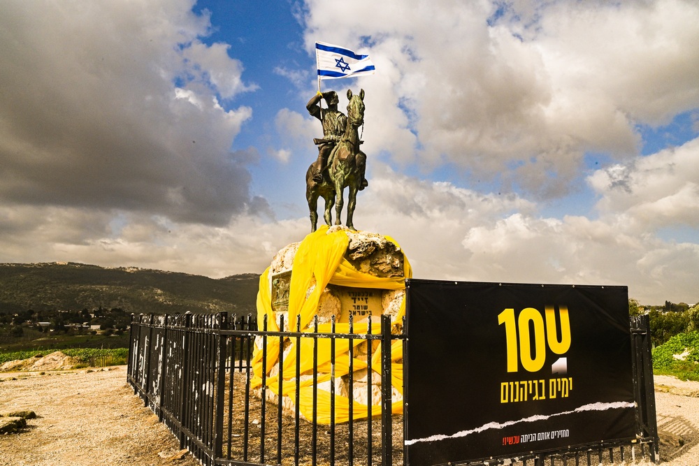 פסל אלכסנדר זייד מלופף בצהוב בקריאה להשבת החטופים